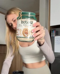 customer holds the peanut butter botenz powder jar